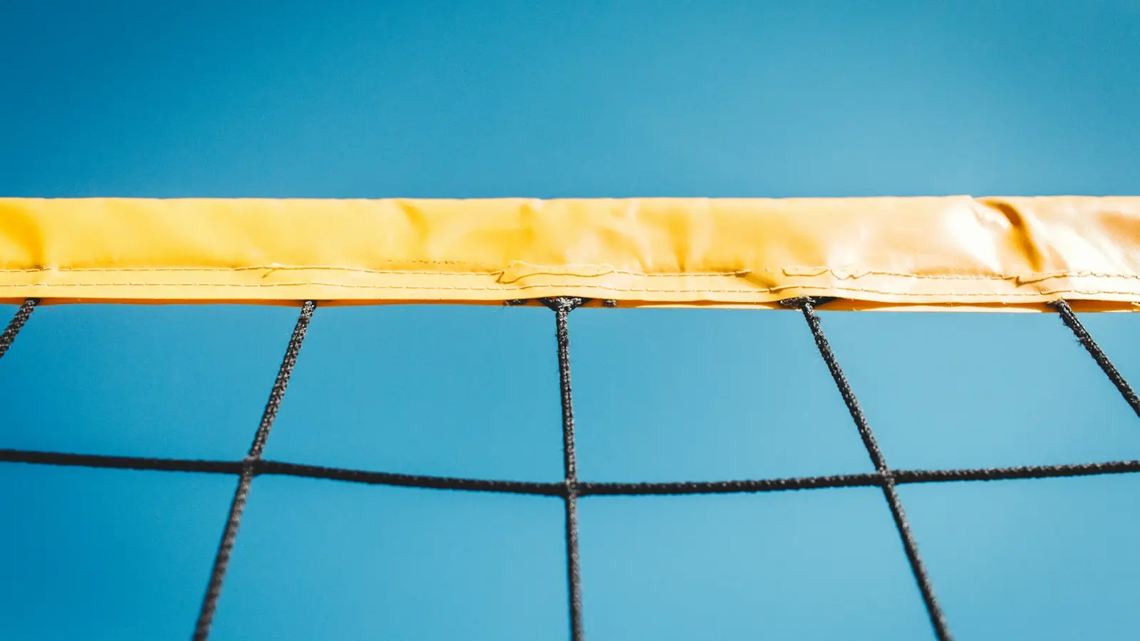 Primer plano de la banda superior y la malla de una red de voleibol