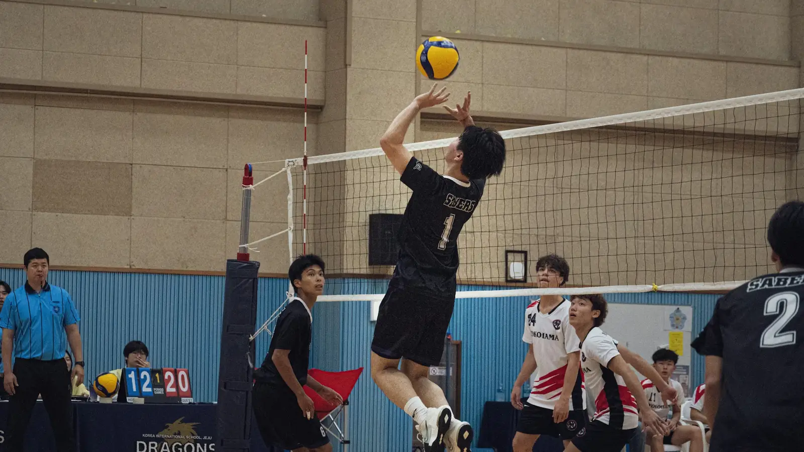 Volleyball setter jumping to set the ball at the net