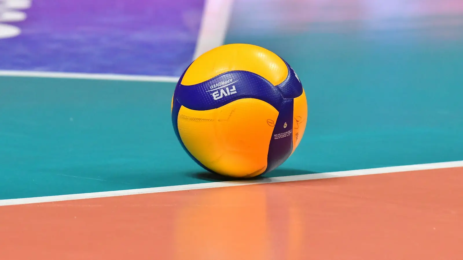 Balón de voleibol sobre la línea de una pista cubierta